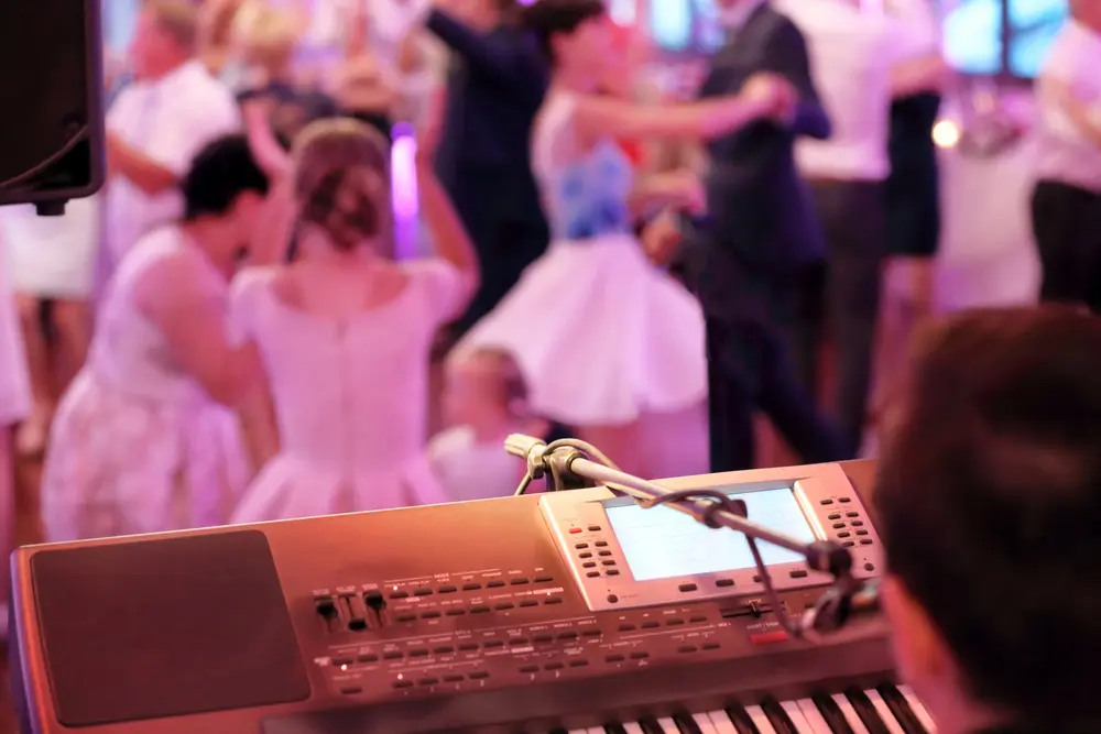 Hochzeitspaar und Gäste auf der Tanzfläche mit DJ